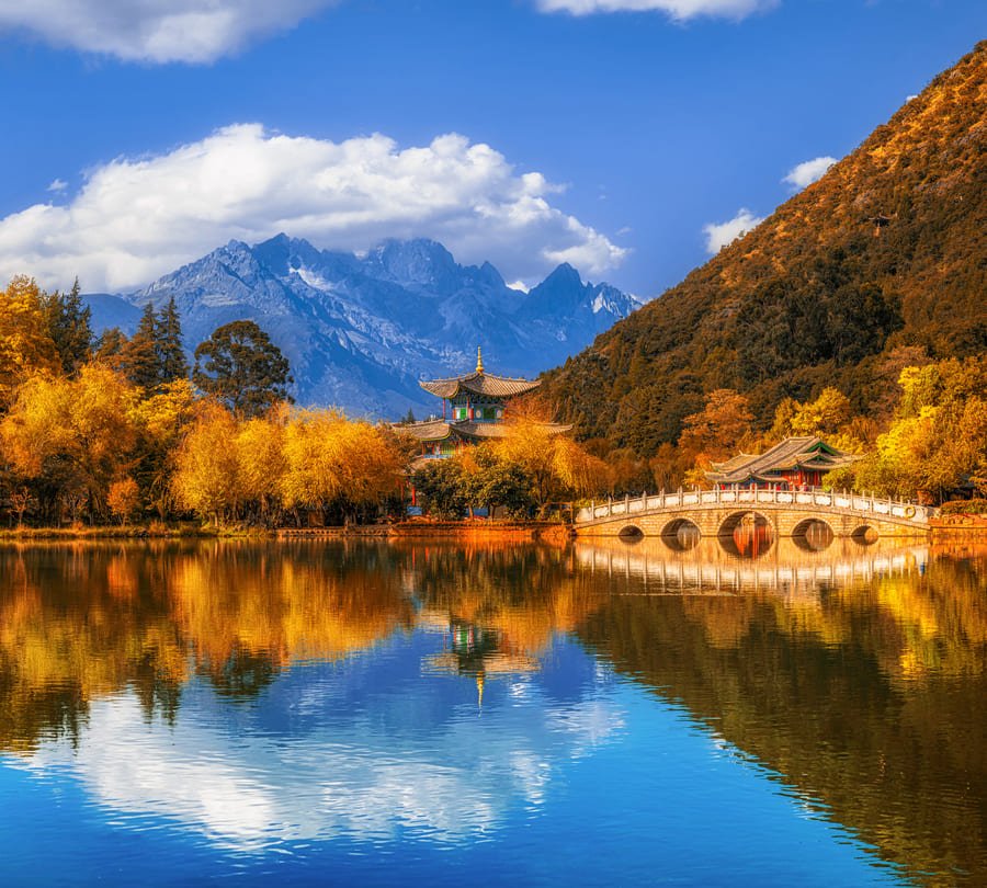 Rio Lijian azul rodeado de montañas y cielo azul